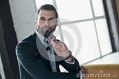 Young stylish businessman leader indoors at office holding sungl Stock Photo