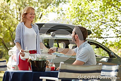 Young beardy guy taking cup of coffee from a tray offered by beautiful blonde female Stock Photo