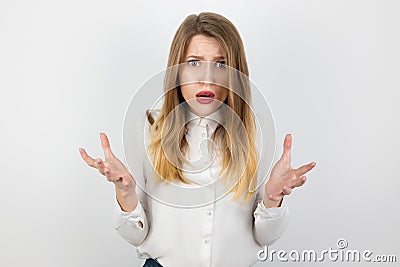 Young beatuiful blond angry woman looks desperate standing on isolated white background, splash of emotions Stock Photo