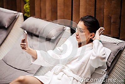 Young beauitiful woman wearing white bathrobe lying on the loung Stock Photo