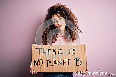 Young beautiful activist woman with curly hair and piercing protesting asking for change planet with a confident expression on Stock Photo