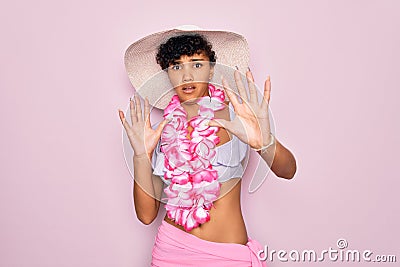 Young beautiful african american tourist woman wearing bikini and hawaiian lei flowers afraid and terrified with fear expression Stock Photo