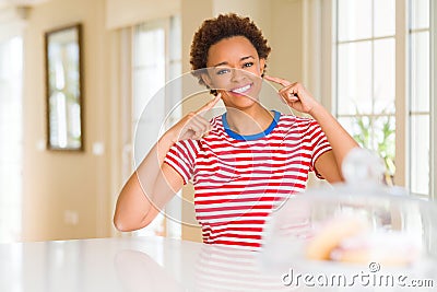 Young beautiful african american woman at home smiling confident showing and pointing with fingers teeth and mouth Stock Photo