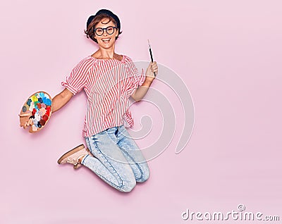 Young beautiful artist woman wearing glasses and beret smiling happy Stock Photo