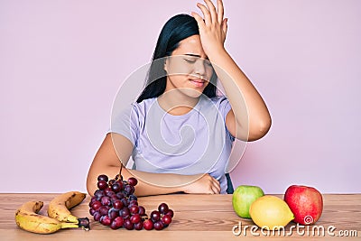 Young beautiful asian girl eating fresh and healthy fruit surprised with hand on head for mistake, remember error Stock Photo