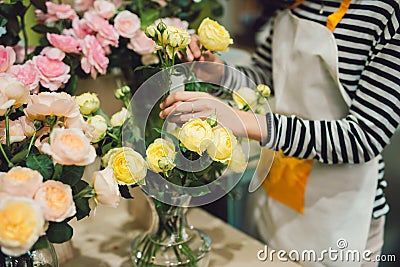 Young beautiful asian girl florist taking care of flowers at workplace Stock Photo