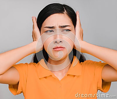 Young beautiful asian woman,long black hair, wore orange t shirt, Showing a disgruntled expression, Don`t want to listen, angry o Stock Photo