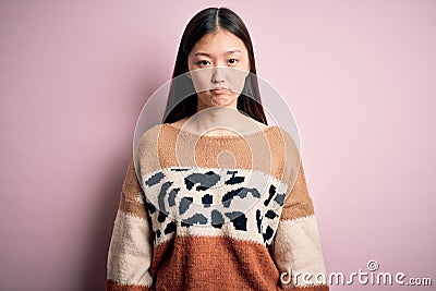 Young beautiful asian woman wearing animal print fashion sweater over pink isolated background depressed and worry for distress, Stock Photo