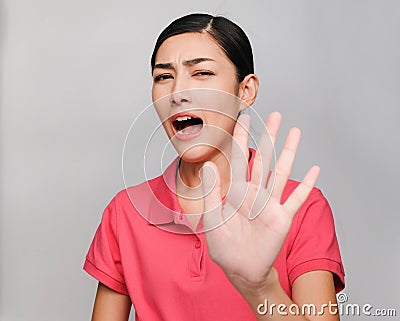 Young beautiful asian woman wore pink t shirt, Raise her hand,Showed prohibit expression , on gray background Stock Photo