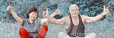 Young beautiful athletic couple does gymnastics and shows thumbs up Stock Photo