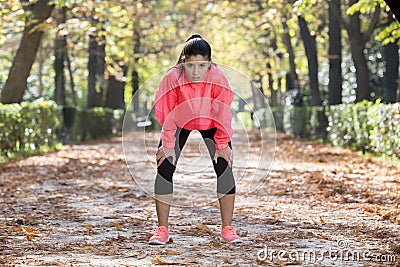 Attractive sport woman in runner sportswear breathing gasping and taking a break tired and exhausted after running workout on Autu Stock Photo