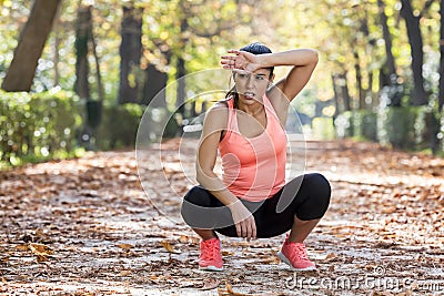 Attractive sport woman in runner sportswear breathing gasping and taking a break tired and exhausted after running workout on Autu Stock Photo