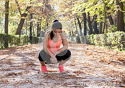 Attractive sport woman in runner sportswear breathing gasping and taking a break tired and exhausted after running workout on Autu Stock Photo