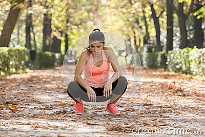 Attractive sport woman in runner sportswear breathing gasping and taking a break tired and exhausted after running workout on Autu Stock Photo