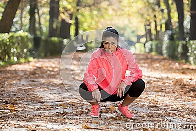 Attractive sport woman in runner sportswear breathing gasping and taking a break tired and exhausted after running workout on Autu Stock Photo