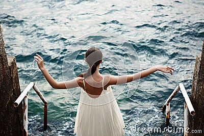 Young beautiful ballerina dancing and posing outside, sea background. Stock Photo