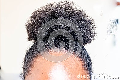 Young beautiful black girl with natural Afro Kinky hair bun. African American Kinky curly woman with cute bun for creative elegant Stock Photo
