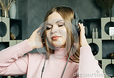 Young beautiful woman in casual outfit enjoying the music at home. Lifestyle, tehnology and people concept. Stock Photo