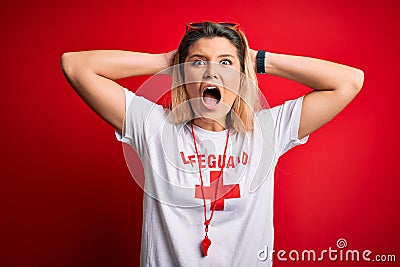 Young beautiful blonde lifeguard woman wearing t-shirt with red cross and whistle Crazy and scared with hands on head, afraid and Editorial Stock Photo