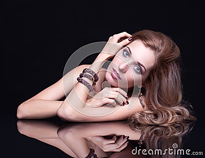 Young beautiful blonde woman sitting at mirror table on black ba Stock Photo