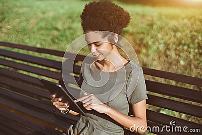 Cheerful black gril calling her friend using tablet pc Stock Photo