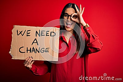 Young beautiful brunette activist woman protesting for a change holding banner with happy face smiling doing ok sign with hand on Stock Photo