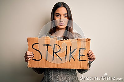 Young beautiful brunette activist woman protesting holding poster with strike message with a confident expression on smart face Stock Photo