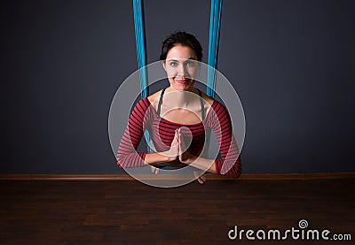 Young beautiful brunette woman doing fly yoga. Sitting in hammoc Stock Photo