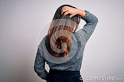 Young beautiful brunette woman wearing casual sweater standing backward over isolated white background Stock Photo