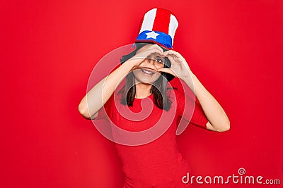 Young beautiful brunette woman wearing united states hat celebrating independence day Doing heart shape with hand and fingers Stock Photo