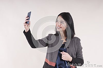 Young beautiful businesswoman cheerful phone smiling braces studio, making selfie Stock Photo