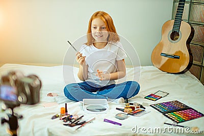 Young caucasian child blogger show her new cosmetics at camera Stock Photo