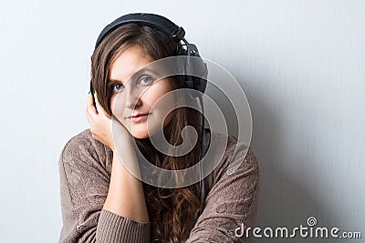 caucasian woman with curly hair in sweater with headphones Stock Photo