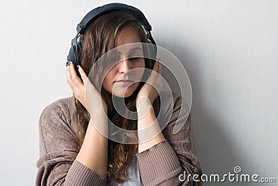 Caucasian woman with curly hair in sweater with headphones Stock Photo