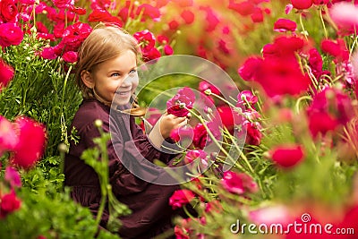 Sweet little girl in a meadow with wild spring flowers Stock Photo