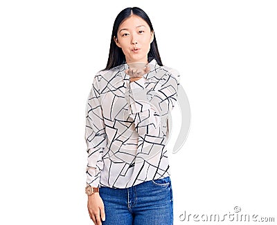 Young beautiful chinese woman wearing casual shirt looking at the camera blowing a kiss with hand on air being lovely and sexy Editorial Stock Photo