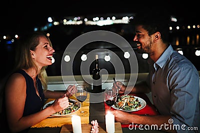 Young beautiful couple having romantic dinner on rooftop Stock Photo