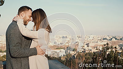 Young beautiful couple hug and kiss against the panorama of Rome, Italy. Romantic date of happy man and woman. Stock Photo