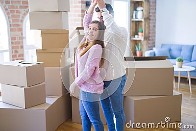 Young beautiful couple in love celebrating dancing moving to a new home, smiling very happy for new apartment Stock Photo