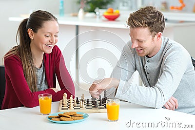 Young beautiful couple playing chess indoor Stock Photo