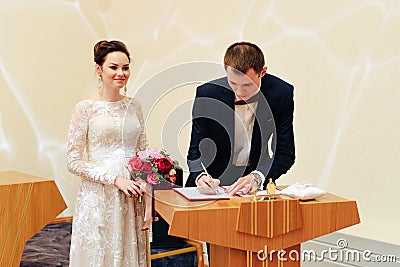 Young beautiful couple puts a ring on the hand, the newlyweds exchange rings Stock Photo