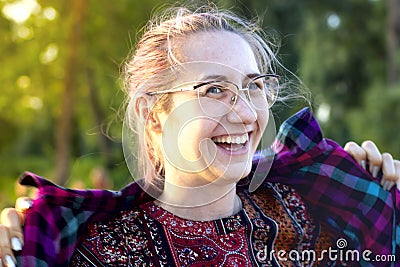 A young beautiful cute happy girl with long hair and glasses laughs sincerely, a big wide smile on her face. She`s Stock Photo