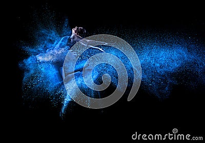 Young beautiful dancer jumping into blue powder cloud Stock Photo