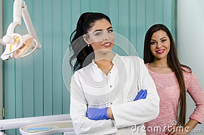 Young beautiful dentist and her patent behind her. Stock Photo
