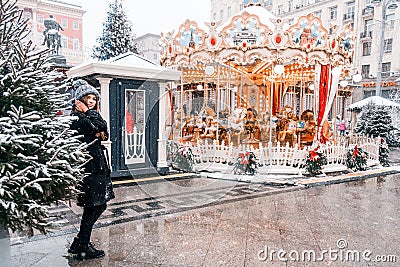 Young beautiful fashion girl is enjoying her time through winter holiday in Christmas evening, Moscow, Tverskaya Square Stock Photo