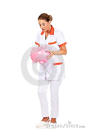 Young beautiful female doctor or nurse holding a piggybank Stock Photo