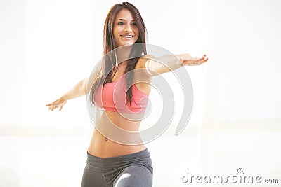 Young beautiful female doing yoga warrior pose Stock Photo