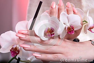 Graceful Hands: Pink Spring Manicure and White Orchids Stock Photo