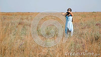 Young Beautiful Girl in a Blue Dress Enjoys Flowers Steppe. a Young Woman in a Meadow. Steppe. Blossoming Sunny Meadow Stock Footage - Video of beauty, model: 77302656 
