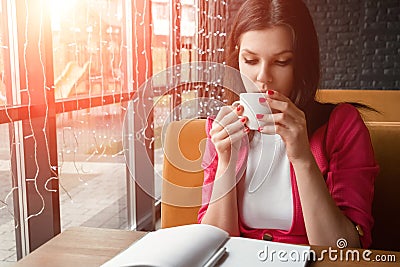 Young beautiful girl, businesswoman drinking tea or coffee sitting in cafe. Business lunch, break Stock Photo